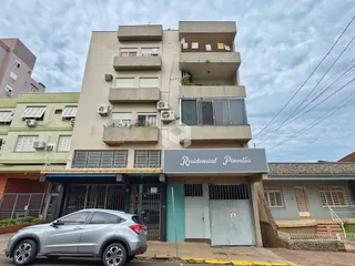 Fachada de um prédio residencial em Lajeado, Brasil, com apartamentos e garagem na frente.