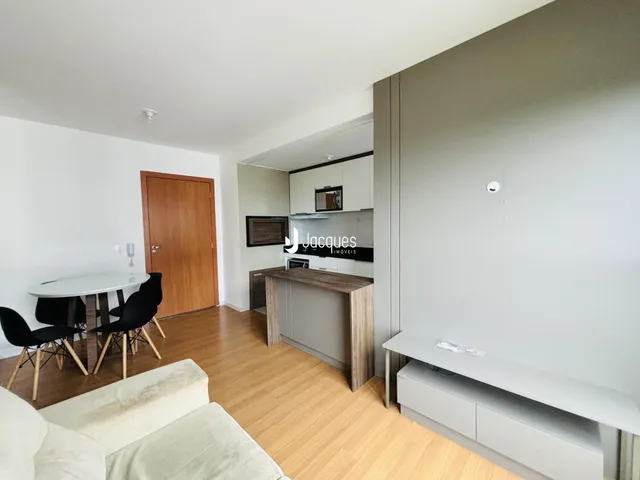 Ambiente de sala de estar e jantar com piso de madeira clara.