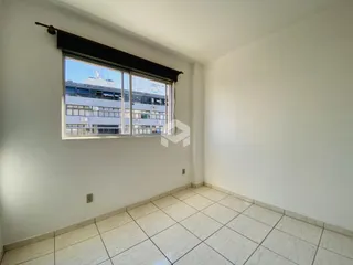 A sala apresenta piso de cerâmica clara e paredes brancas.