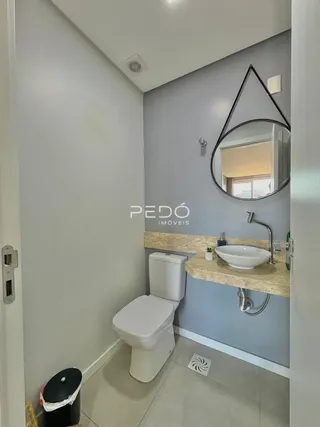 Foto de um banheiro interno com azulejos claros e louças sanitárias.