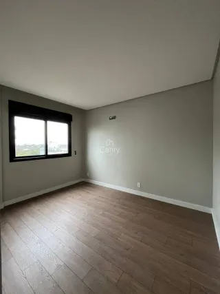 Foto de um cômodo interno com piso de madeira e uma janela.