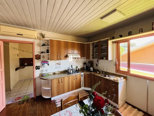 Foto interna de uma cozinha com armários de madeira e piso de madeira.