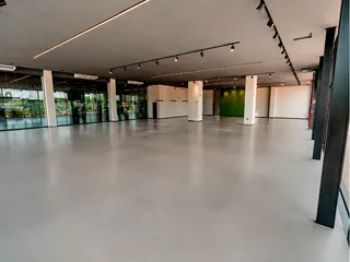 Espaço interno amplo com piso claro e teto alto.