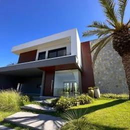 Fachada moderna de uma residência com paisagismo verde em Lajeado.