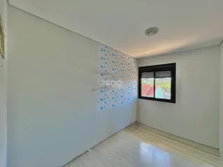 Interior de uma sala com parede decorativa azul e piso de madeira clara.