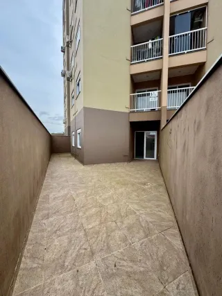 Vista de um corredor externo pavimentado entre edifícios residenciais.