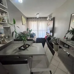 Sala de estar com cortinas claras e iluminação natural.
