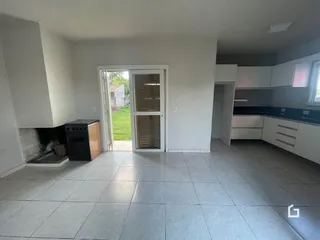 Vista interna de uma sala com piso de cerâmica e porta de entrada.