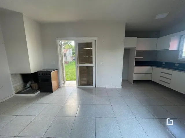 Vista interna de uma sala com piso de cerâmica e porta de entrada.