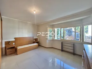 Quarto com cama de madeira e piso de cerâmica em um imóvel no Brasil.