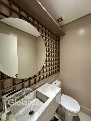Foto de um banheiro com bancada de mármore e vaso sanitário branco.