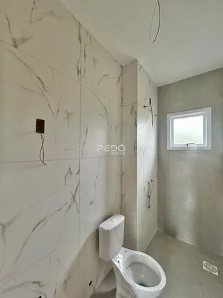 Foto de um banheiro com revestimento de mármore branco nas paredes.