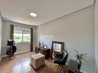 Ambiente interno de uma sala com piso de madeira e janela.