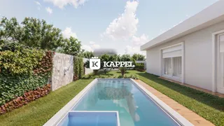 Foto da piscina externa com paisagismo verde ao lado de uma residência branca.