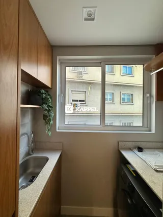 Esta é uma vista de uma cozinha com armários de madeira e bancada.