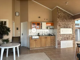 Cozinha com armários de madeira e piso de cerâmica em um imóvel.