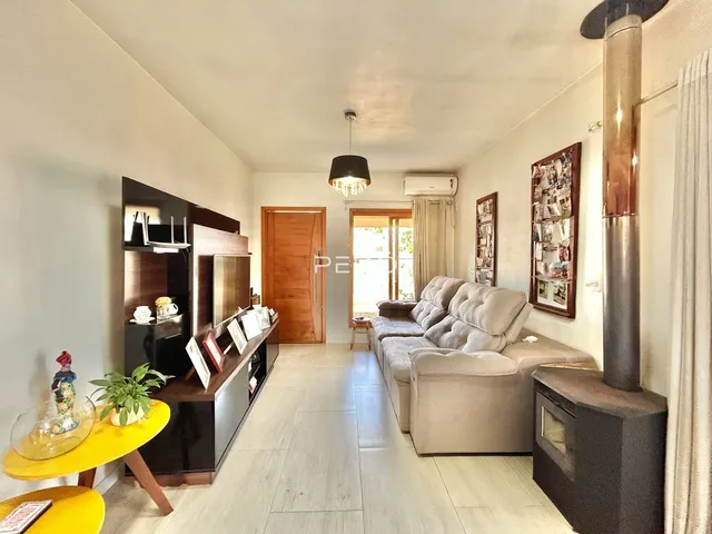 Sala de estar com sofá e móveis de madeira clara em um apartamento.