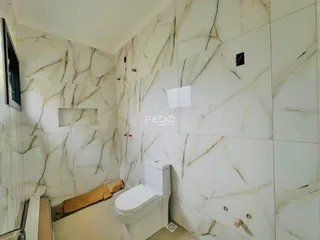 Foto de um banheiro com revestimento de mármore nas paredes.