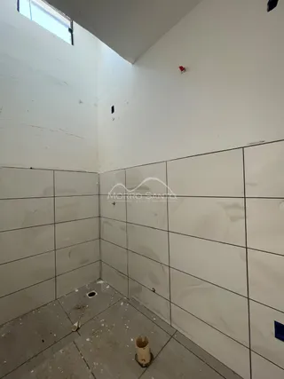 Parede interna com revestimento de azulejos brancos em um ambiente.