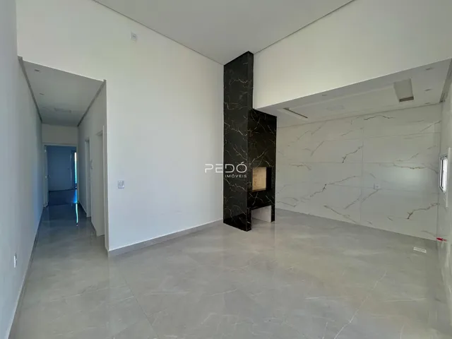 Hall de entrada moderno com piso de porcelanato e parede de destaque em mármore escuro.