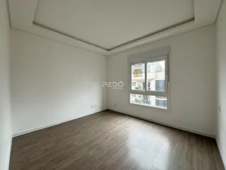 Foto de um cômodo interno com piso de madeira clara e paredes brancas.