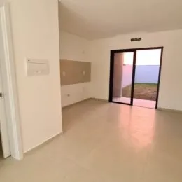 Ambiente interno de uma sala ampla com piso claro.