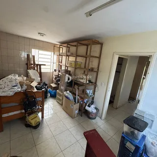 Interior de uma sala com móveis e caixas em uma residência.