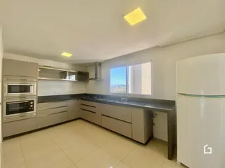 Cozinha moderna com armários e eletrodomésticos brancos.