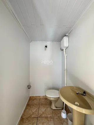Foto de um banheiro com piso de cerâmica e louças sanitárias.