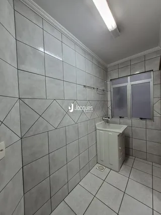 Foto de um banheiro com revestimento de azulejos cinzas.