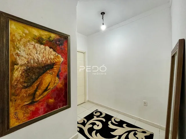 Hall de entrada com parede branca e piso de cerâmica.