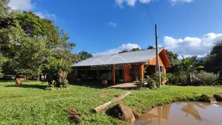 Fachada de uma casa em Lajeado, Brasil, com telhado de metal e área gramada.