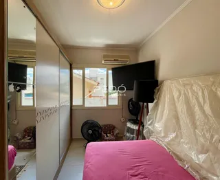 Quarto com cama e armário de parede em um imóvel no Brasil.