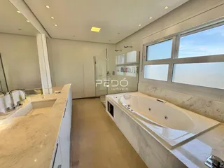 Banheiro moderno com banheira e piso de mármore claro.