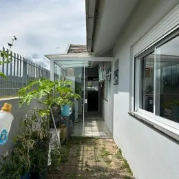 Fachada branca de uma residência com vegetação na entrada em Lajeado, Brasil.