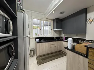 Foto de uma cozinha moderna com armários cinzas e bancadas escuras.