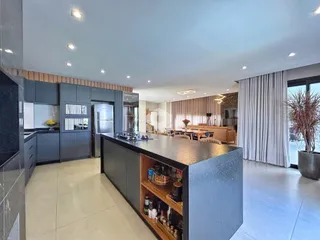 Vista de uma cozinha moderna com ilha e armários escuros.