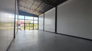Foto de um espaço amplo com paredes brancas e estrutura de teto metálico.