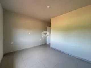 Interior de uma sala com piso de cerâmica clara e paredes brancas.