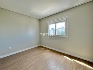 Ambiente interno de um cômodo com piso de madeira e janela.