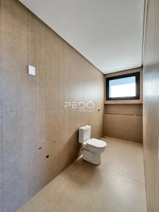 Foto de um banheiro com piso claro e paredes bege.