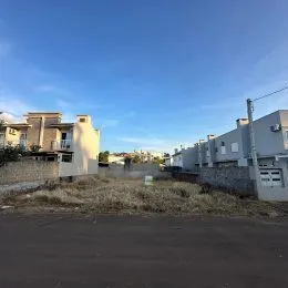 Vista externa de uma propriedade com vegetação seca em primeiro plano.