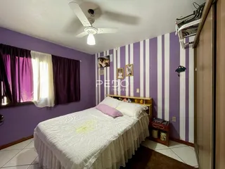 Quarto com cama e janela em ambiente com parede listrada.