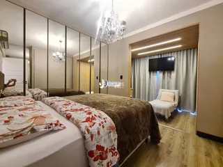 Quarto com duas camas e espelho grande em um imóvel.