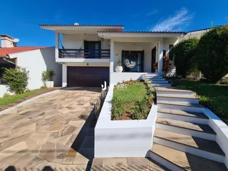 Fachada de uma casa em Lajeado, Brasil, com jardim e acesso por escadaria.