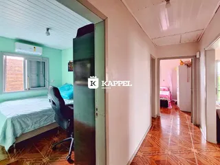 Quarto com cama e janela em um imóvel com piso de madeira.