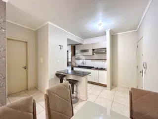 Ambiente interno de sala com vista para a cozinha em um imóvel no Brasil.