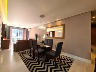 Sala de estar com piso de madeira e mesa de jantar.