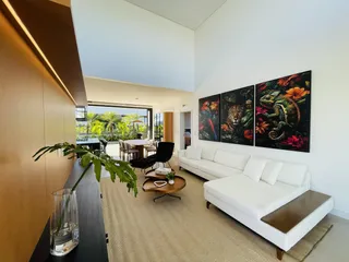 Sala de estar ampla com sofá branco e arte na parede.