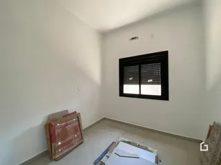 Ambiente interno de uma sala em reforma com paredes brancas.